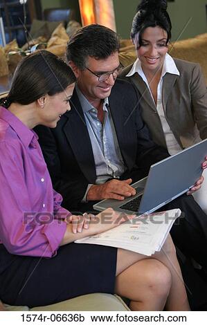 Stock Image - High angle view of two businesswomen sitting with a businessman. Fotosearch