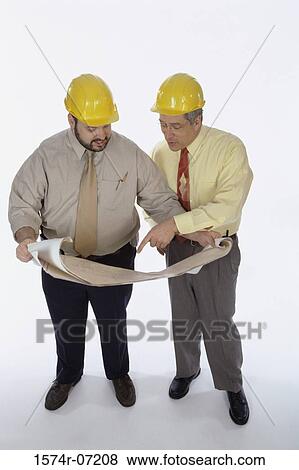 Stock Photo - High angle view of two foremen working on blueprints. Fotosearch