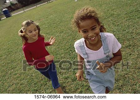 High angle view of two girls playing together on a lawn View Large Photo Image Picture - High angle view of two girls playing together on a lawn. Fotosearch