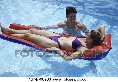 Stock Photograph - High angle view of young couple together in a swimming pool. Fotosearch