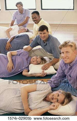 Stock Image - Husbands and their pregnant wives at a prenatal class. Fotosearch