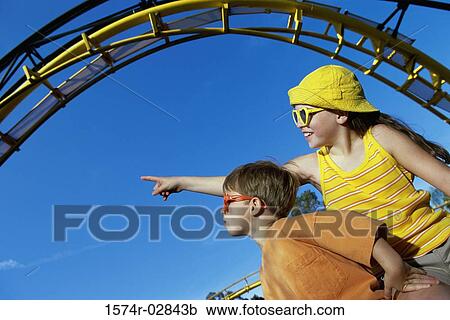 Low angle view of a boy and a girl in an amusement park View Large Photo Image Stock Image - Low angle view of a boy and a girl in an amusement park. Fotosearch