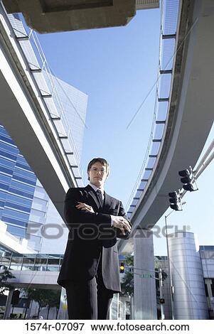 Low angle view of a businessman standing View Large Photo Image Stock Photo - Low angle view of a businessman standing. Fotosearch