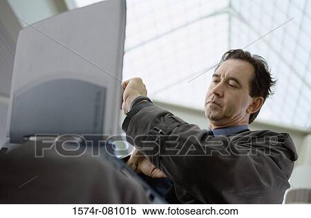 Low angle view of a businessman with a laptop sitting and looking at his wristwatch View Large Photo Image Stock Image - Low angle view of a businessman with a laptop sitting and looking at his wristwatch. Fotosearch