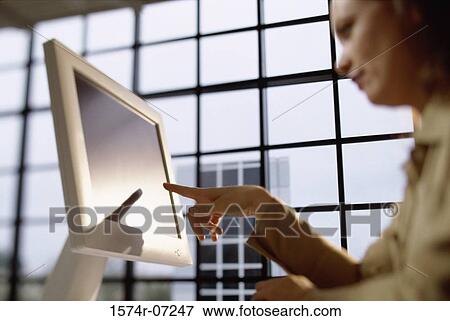 Low angle view of a businesswoman pointing to a computer monitor View Large Photo Image Stock Photo - Low angle view of a businesswoman pointing to a computer monitor. Fotosearch