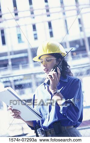 Low angle view of a forewoman talking on a walkie-talkie View Large Photo Image Stock Image - Low angle view of a forewoman talking on a walkie-talkie. Fotosearch