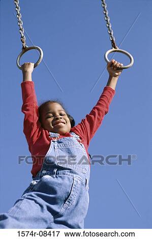 Low angle view of a girl hanging on rings View Large Photo Image Stock Photo - Low angle view of a girl hanging on rings. Fotosearch