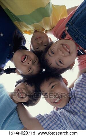 Stock Image - Low angle view of a group of children in a huddle. Fotosearch