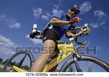 Low angle view of a mature man riding a bicycle View Large Photo Image Stock Image - Low angle view of a mature man riding a bicycle. Fotosearch