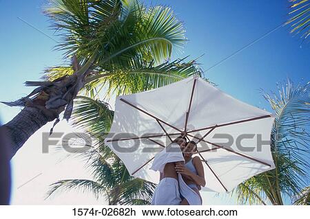 Low angle view of a young couple embracing on the beach View Large Photo Image Stock Image - Low angle view of a young couple embracing on the beach. Fotosearch