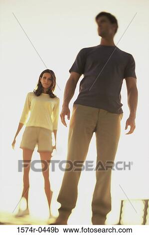 Low angle view of a young couple standing View Large Photo Image Stock Image - Low angle view of a young couple standing. Fotosearch