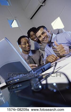 Stock Image - Low angle view of business executives in an office. Fotosearch