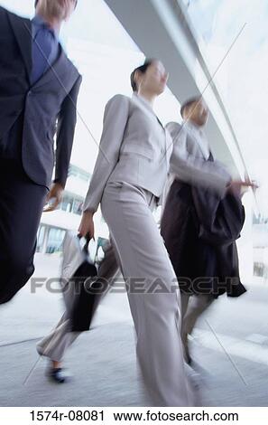 Low angle view of businesswoman and two businessmen walking together View Large Photo Image Stock Image - Low angle view of businesswoman and two businessmen walking together. Fotosearch