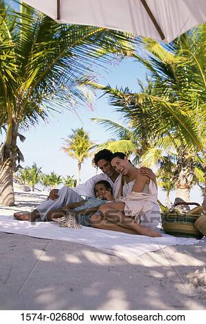 Low angle view of parents sitting with their daughter on the beach View Large Photo Image Stock Image - Low angle view of parents sitting with their daughter on the beach. Fotosearch