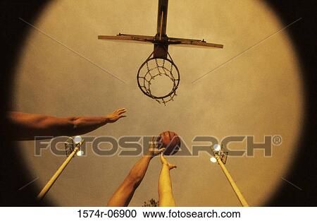 Stock Image - Low angle view of people's hands reaching out for a basketball. Fotosearch