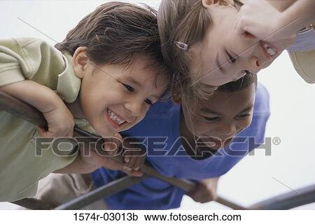Low angle view of two boys and a girl playing View Large Photo Image Stock Image - Low angle view of two boys and a girl playing. Fotosearch