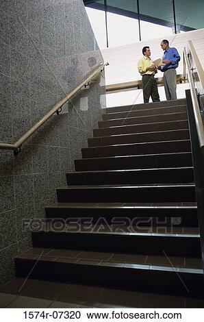 Low angle view of two businessmen standing at the top of a staircase View Large Photo Image Stock Image - Low angle view of two businessmen standing at the top of a staircase. Fotosearch