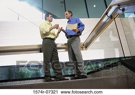 Low angle view of two businessmen discussing on the top of a staircase View Large Photo Image Stock Image - Low angle view of two businessmen discussing on the top of a staircase. Fotosearch