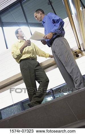 Low angle view of two businessmen discussing on the top of a staircase View Large Photo Image Stock Image - Low angle view of two businessmen discussing on the top of a staircase. Fotosearch