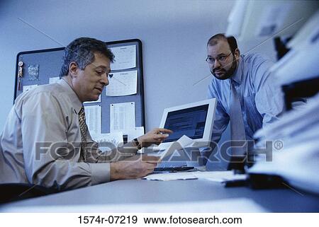 Low angle view of two businessmen discussing in an office View Large Photo Image Stock Photo - Low angle view of two businessmen discussing in an office. Fotosearch