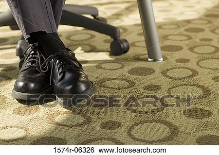 Low section view of a businessman sitting on an office chair View Large Photo Image Stock Photograph - Low section view of a businessman sitting on an office chair. Fotosearch