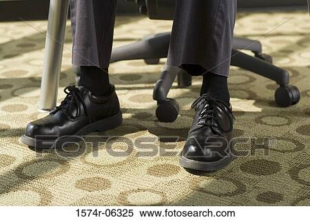Stock Photography - Low section view of a businessman sitting on an office chair. Fotosearch