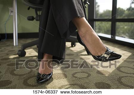 Low section view of a businesswoman sitting on an office chair View Large Photo Image Stock Photo - Low section view of a businesswoman sitting on an office chair. Fotosearch