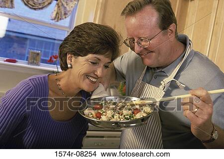 Picture - Man showing a rice dish to a woman. Fotosearch