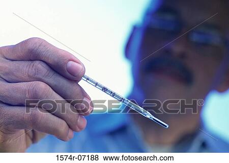 Stock Photo - Mature man holding a thermometer. Fotosearch
