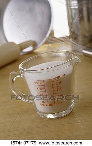 Stock Photo - Measuring cup filled with sugar. Fotosearch