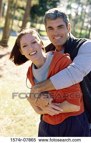Mid adult man holding a mid adult woman View Large Photo Image Stock Photography - Mid adult man holding a mid adult woman. Fotosearch