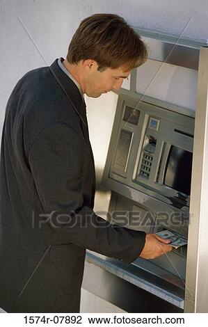 Mid adult man withdrawing cash from an ATM View Large Photo Image Stock Image - Mid adult man withdrawing cash from an ATM. Fotosearch