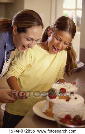Mother and daughter icing a cake together View Large Photo Image Stock Image - Mother and daughter icing a cake together. Fotosearch