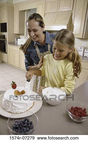 Stock Photo - Mother and daughter icing a cake together. Fotosearch