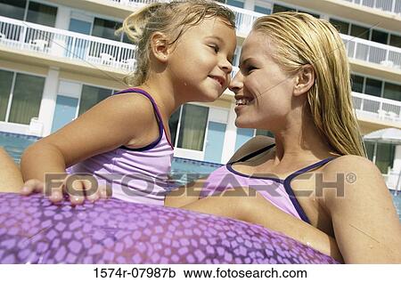 Mother and her daughter playing in a swimming pool View Large Photo Image Stock Image - Mother and her daughter playing in a swimming pool. Fotosearch