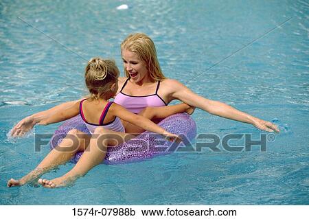 Stock Image - Mother and her daughter playing in a swimming pool. Fotosearch