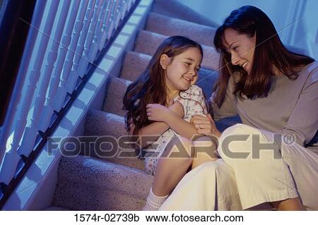 Stock Image - Mother and her daughter sitting on a staircase. Fotosearch