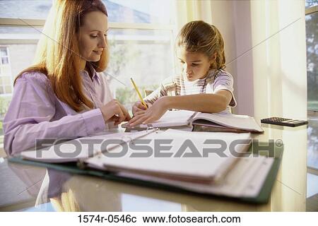 Stock Image - Mother helping her daughter with math homework. Fotosearch