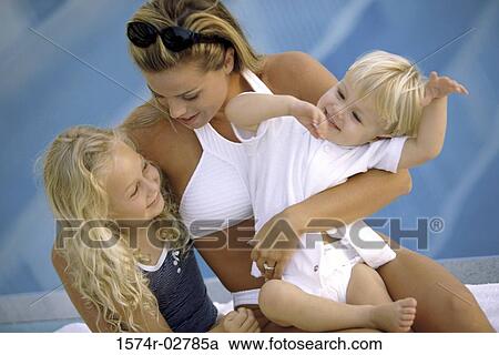 Mother holding her son and daughter beside a swimming pool View Large Photo Image Stock Image - Mother holding her son and daughter beside a swimming pool. Fotosearch
