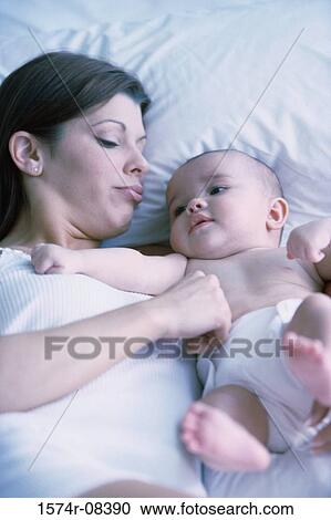 Mother lying in bed with her baby boy View Large Photo Image Stock Image - Mother lying in bed with her baby boy. Fotosearch
