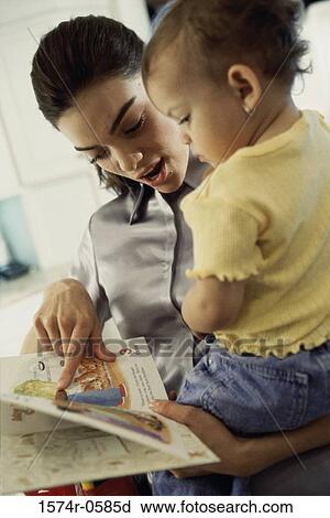 Stock Image - Mother reading a book with her daughter. Fotosearch