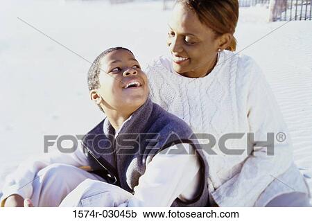 Mother sitting with her son on the beach View Large Photo Image Stock Image - Mother sitting with her son on the beach. Fotosearch