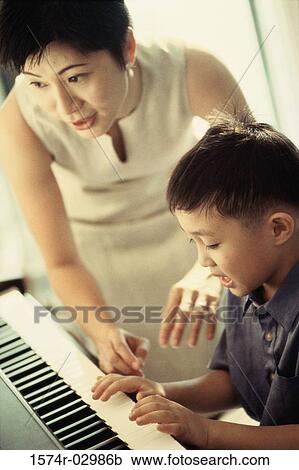 Mother teaching her son the piano View Large Photo Image Stock Image - Mother teaching her son the piano. Fotosearch