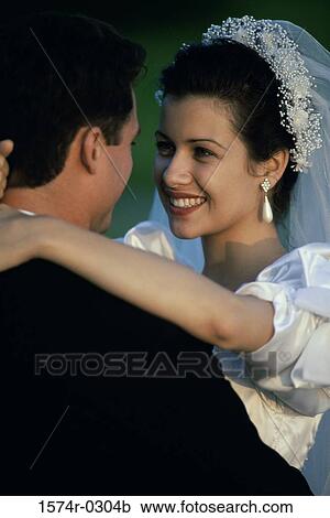 Stock Image - Newly married couple embracing each other. Fotosearch
