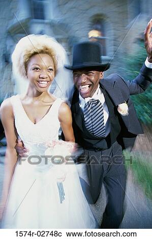 Stock Image - Newlywed couple running together. Fotosearch