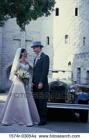 Newlywed couple standing in front of an antique car View Large Photo Image Stock Image - Newlywed couple standing in front of an antique car. Fotosearch