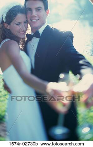 Stock Image - Newlywed couple toasting with glasses of champagne. Fotosearch