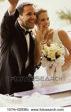 Newlywed couple waving from a convertible car View Large Photo Image Stock Image - Newlywed couple waving from a convertible car. Fotosearch