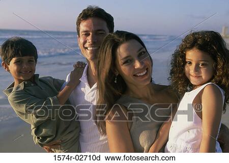 Parents holding their son and daughter on the beach View Large Photo Image Stock Image - Parents holding their son and daughter on the beach. Fotosearch