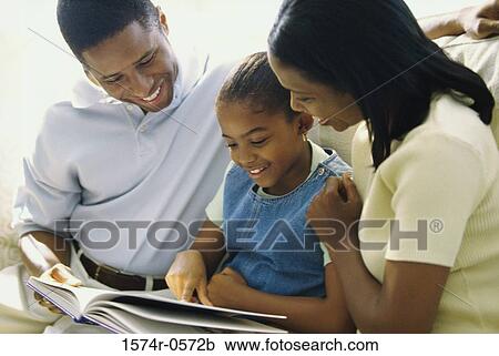 Parents reading a book with their daughter View Large Photo Image Stock Image - Parents reading a book with their daughter. Fotosearch